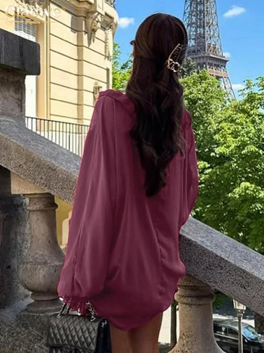 Person in a pink dress standing on a balcony with the Eiffel Tower in the background