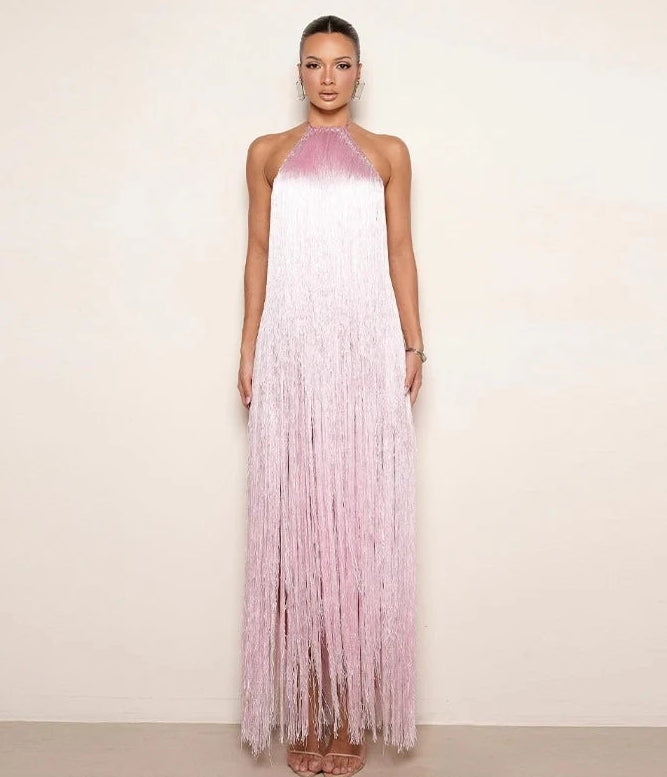 Woman wearing a pink and white fringe dress against a plain background