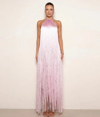 Woman wearing a pink and white fringe dress against a plain background