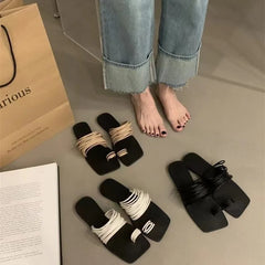 A woman wearing comfortable leather sandals with a delicate thin strap, perfect for a casual summer day.