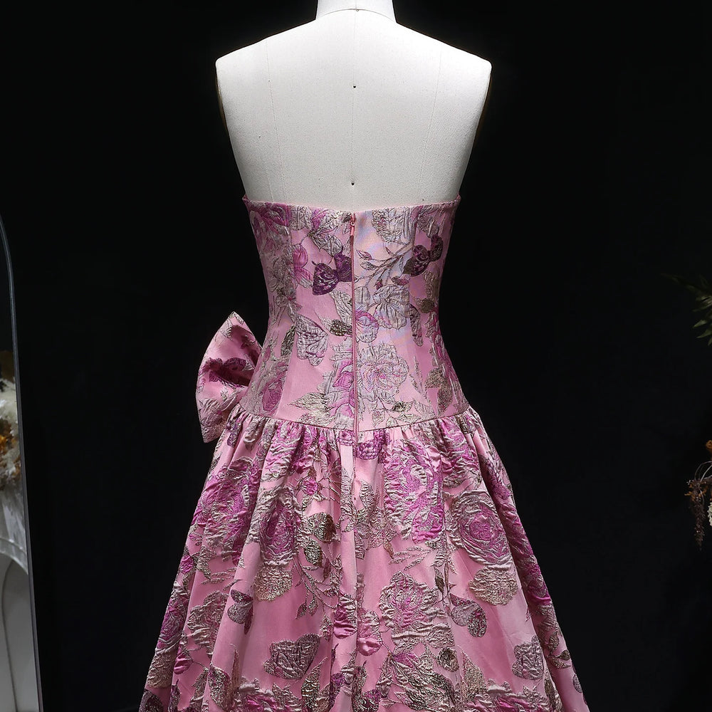 Pink floral dress on a mannequin against a black background