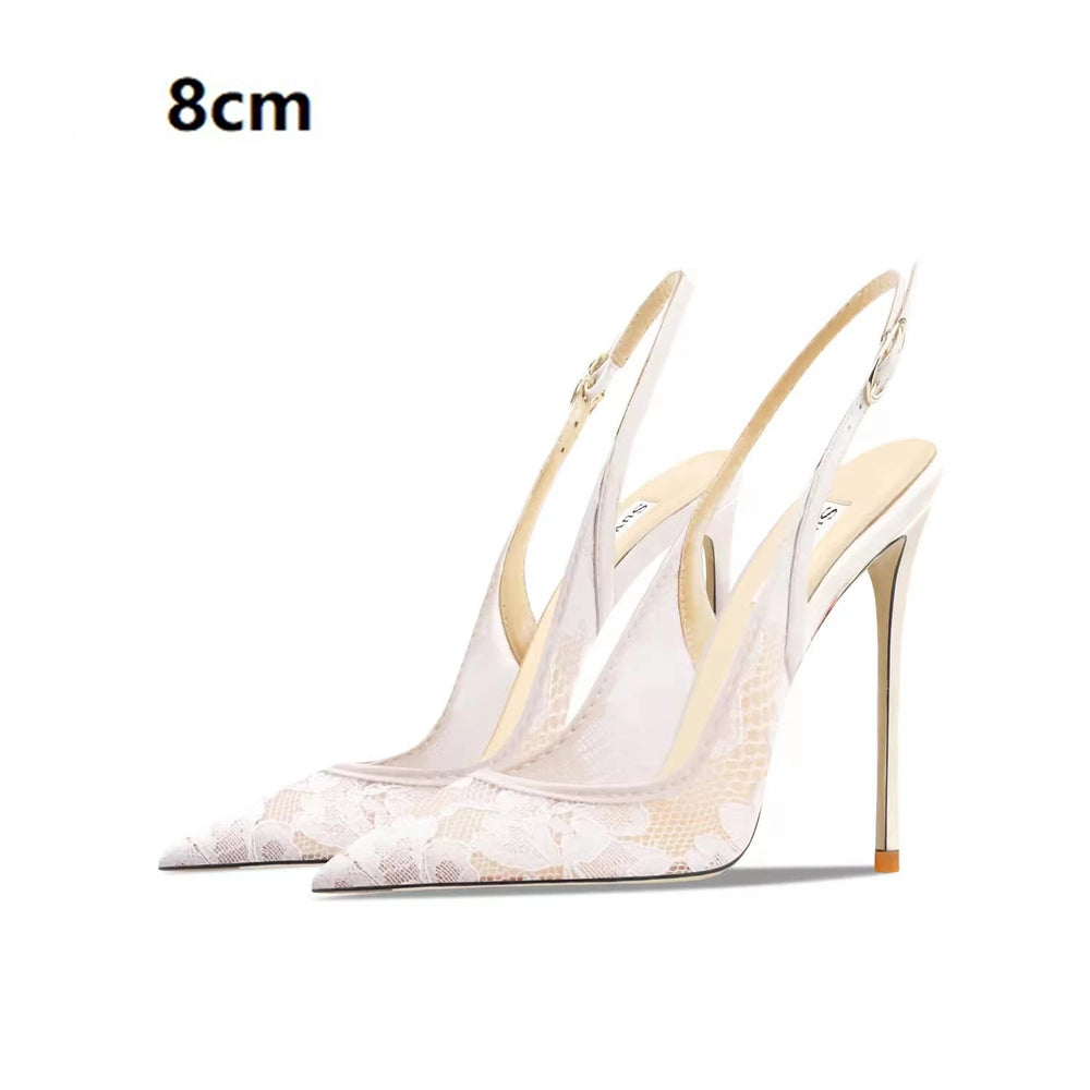 White high-heeled shoes with gold accents on a white background
