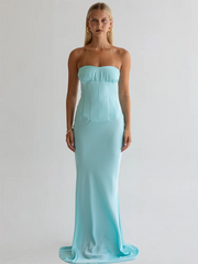 Woman wearing a strapless light blue gown against a plain background
