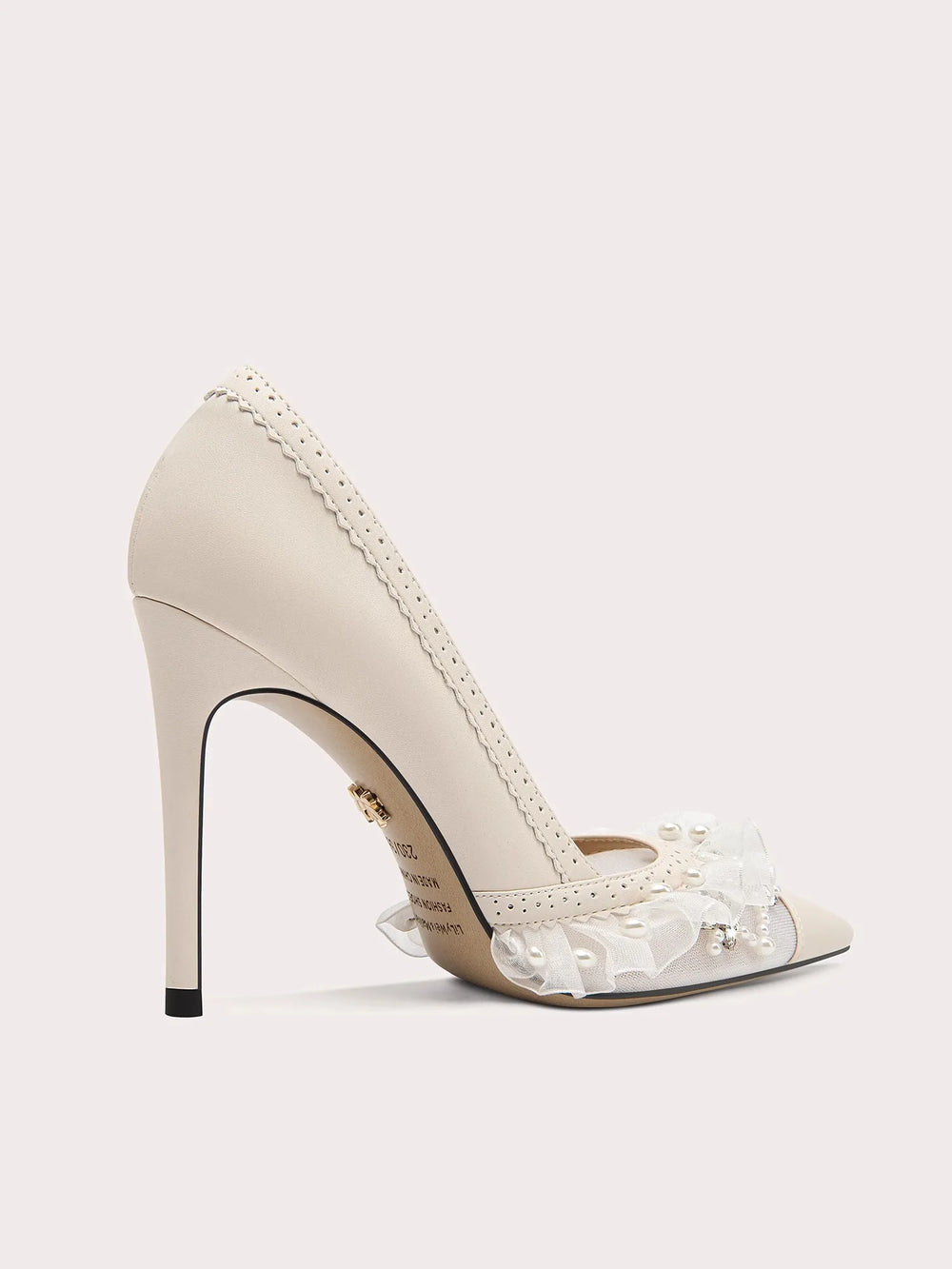 Beige high-heeled shoe with clear gemstones on a white background