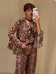 Woman wearing deer print tie neck flare sleeve top
