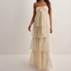 Beige strapless dress with ruffled layers on a white background