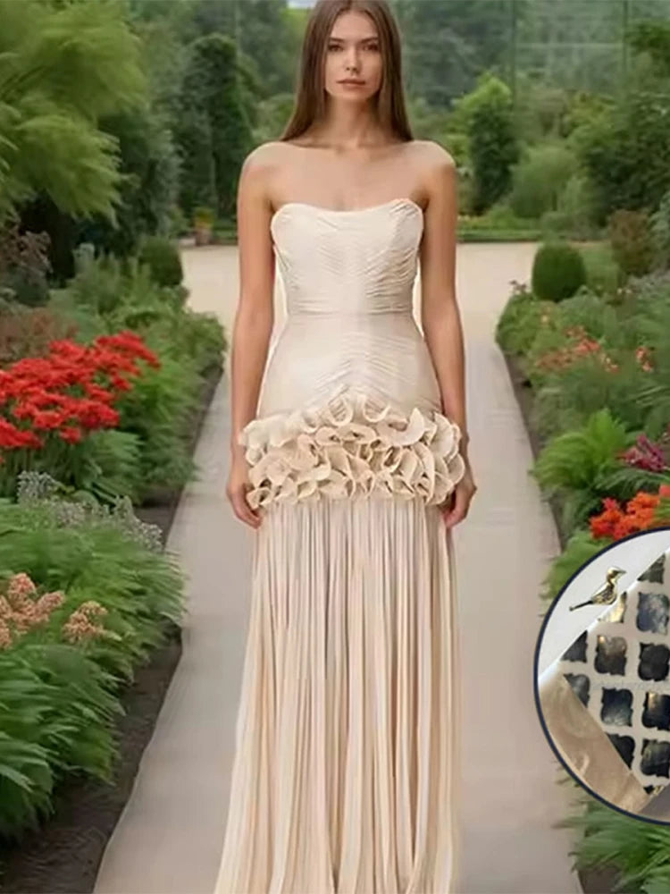 Woman in a strapless, ruffled gown standing in a garden setting