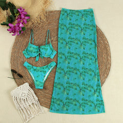 Flat lay of a tie-dye print bikini and maxi skirt with accessories.