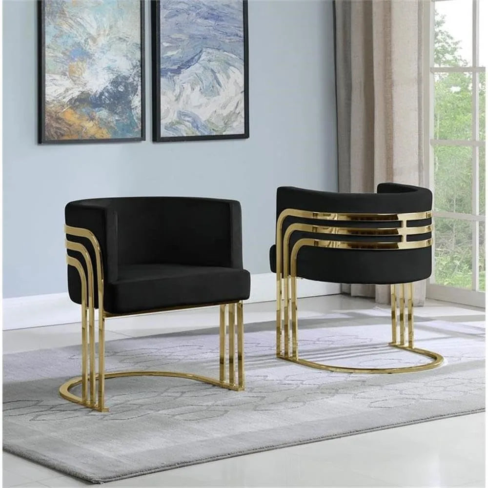 Two black chairs with gold accents in a room with abstract art on the wall.