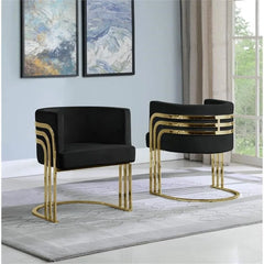 Two black chairs with gold accents in a room with abstract art on the wall.
