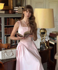 Woman wearing a pink A-line sleeveless cotton midi dress with square neckline, summer fashion
