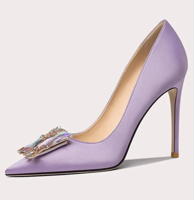 Purple high-heeled shoe with decorative bow on a light gray background