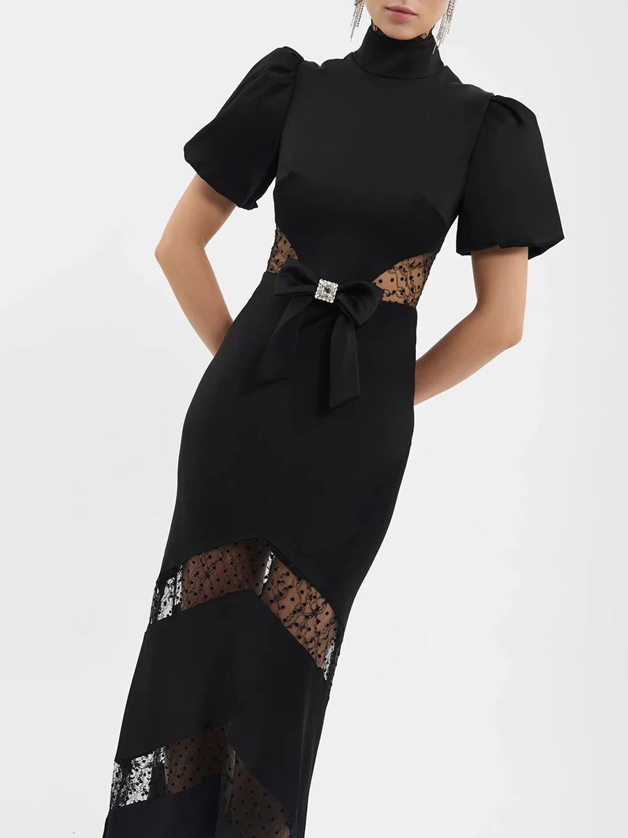 Model wearing black puff sleeve maxi dress with mock neck and lace details