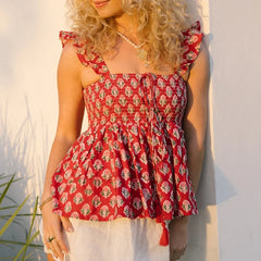 Woman wearing a red floral off-shoulder top against a light background