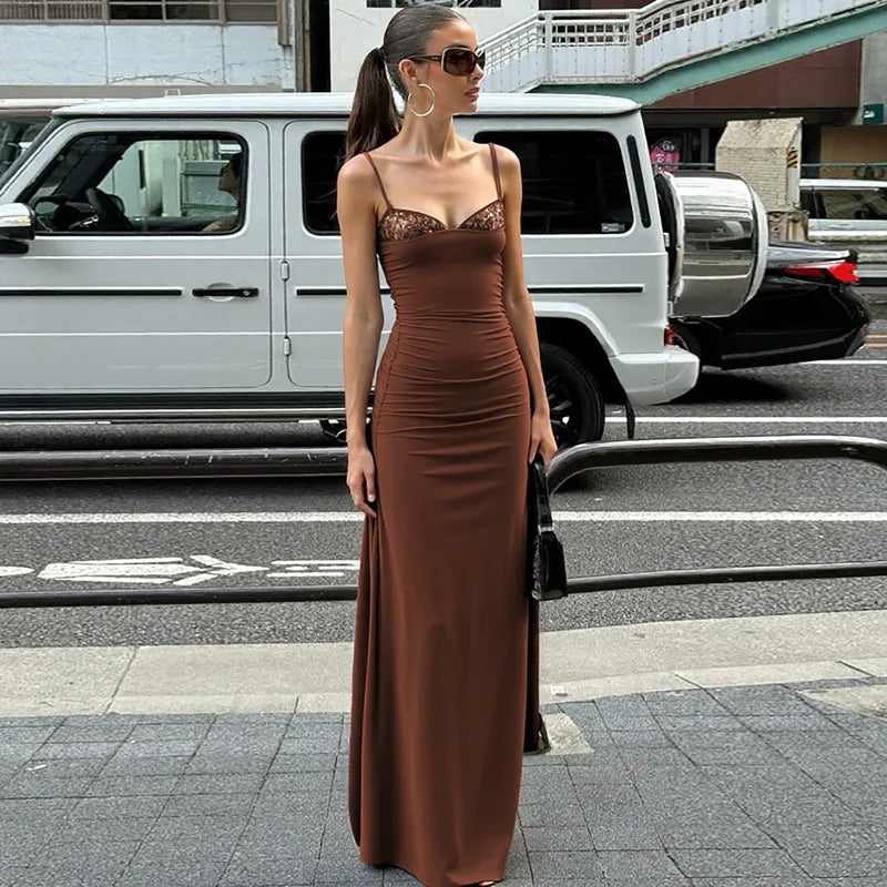 Woman in a brown dress standing on a city street.
