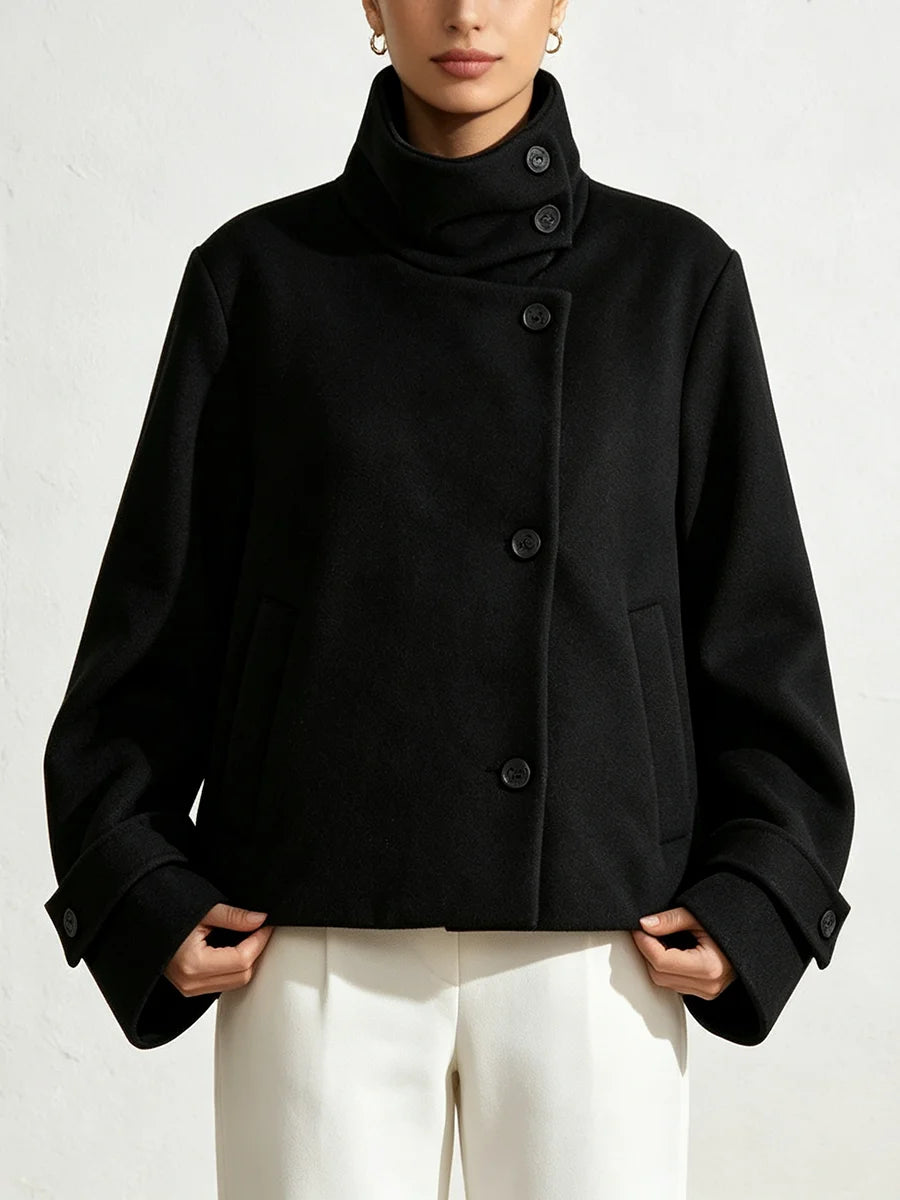 Front view of a black solid cropped jacket with a high stand collar.