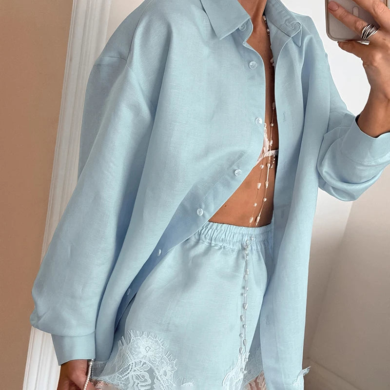 Person wearing a light blue shirt over a lace top, standing against a neutral background.