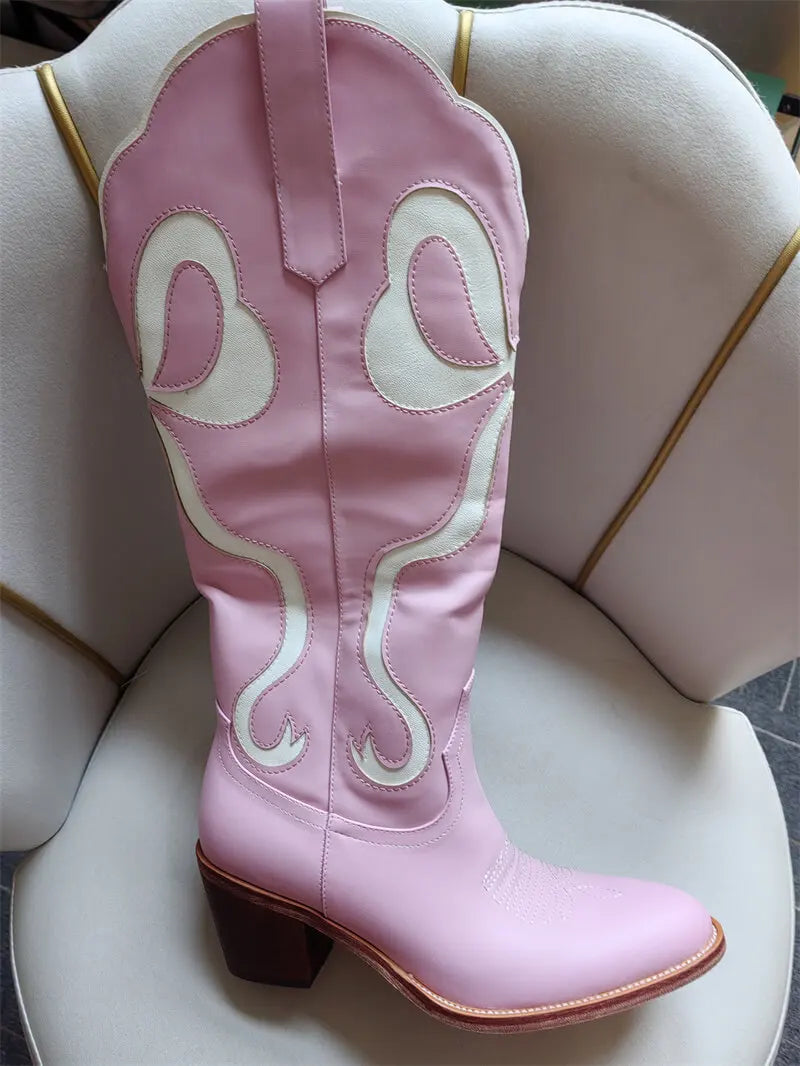 Pink cowboy boot with decorative patterns on a white surface