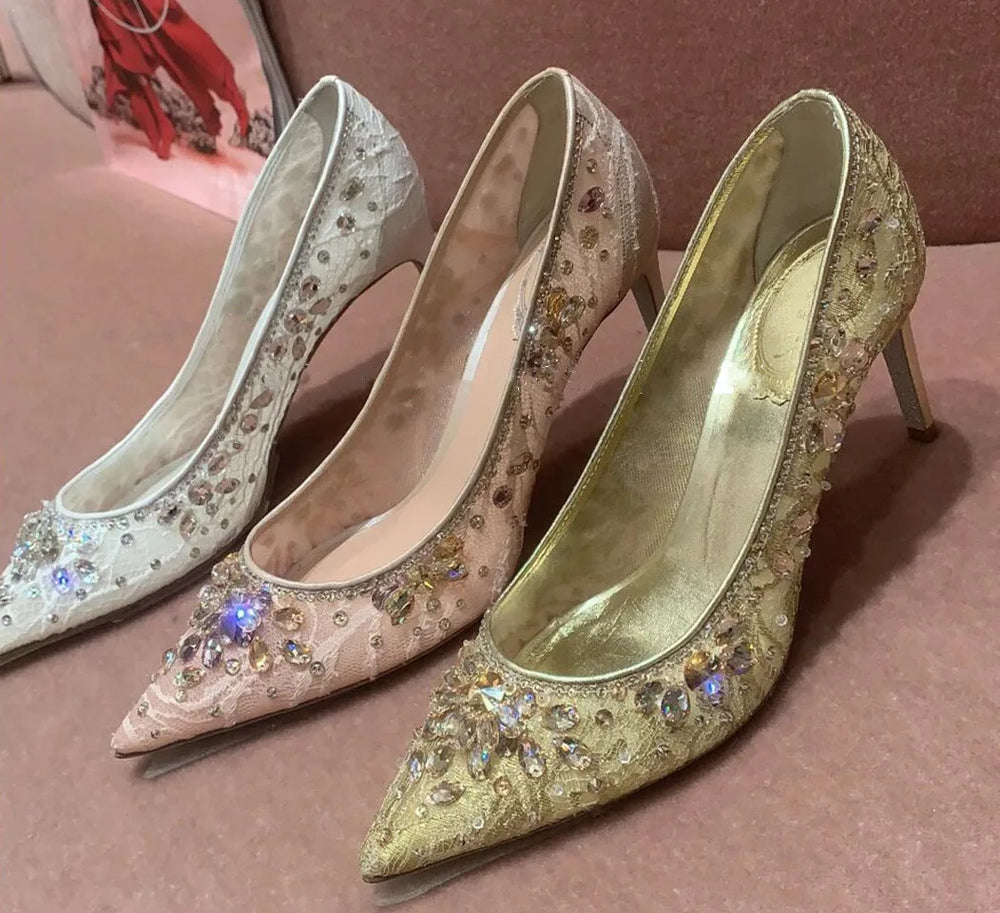 Pair of embellished high-heeled shoes on a pink surface