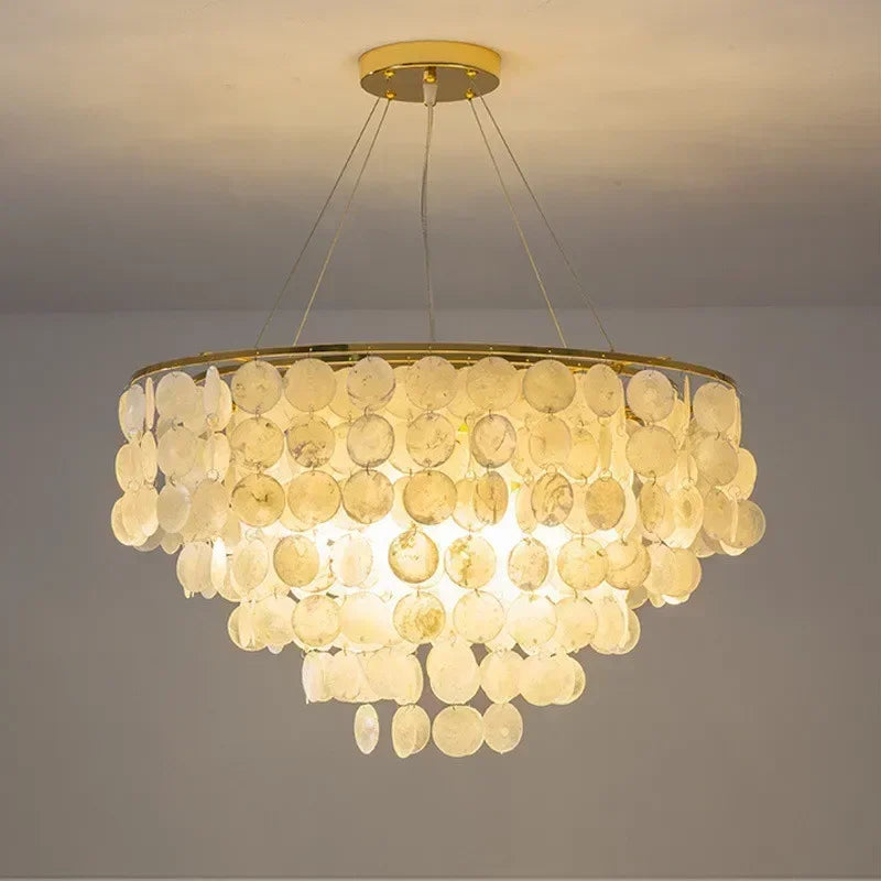 Chandelier with circular design and beige disc-like elements on a plain background