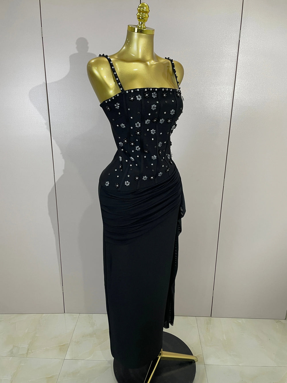 Full view of a black embellished spaghetti strap bodycon dress on a mannequin