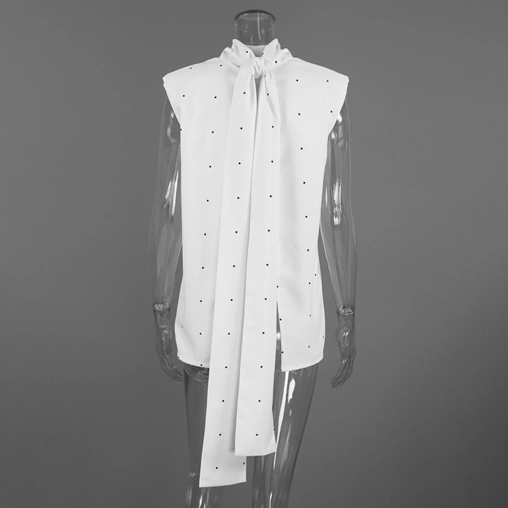 White sleeveless blouse with a large bow on a mannequin against a gray background