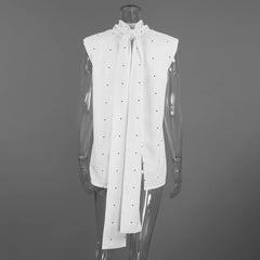 White sleeveless blouse with a large bow on a mannequin against a gray background