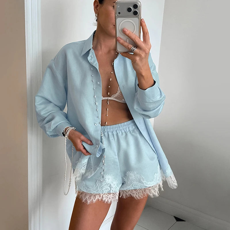 Person wearing a light blue pajama set with lace details, standing in front of a mirror.
