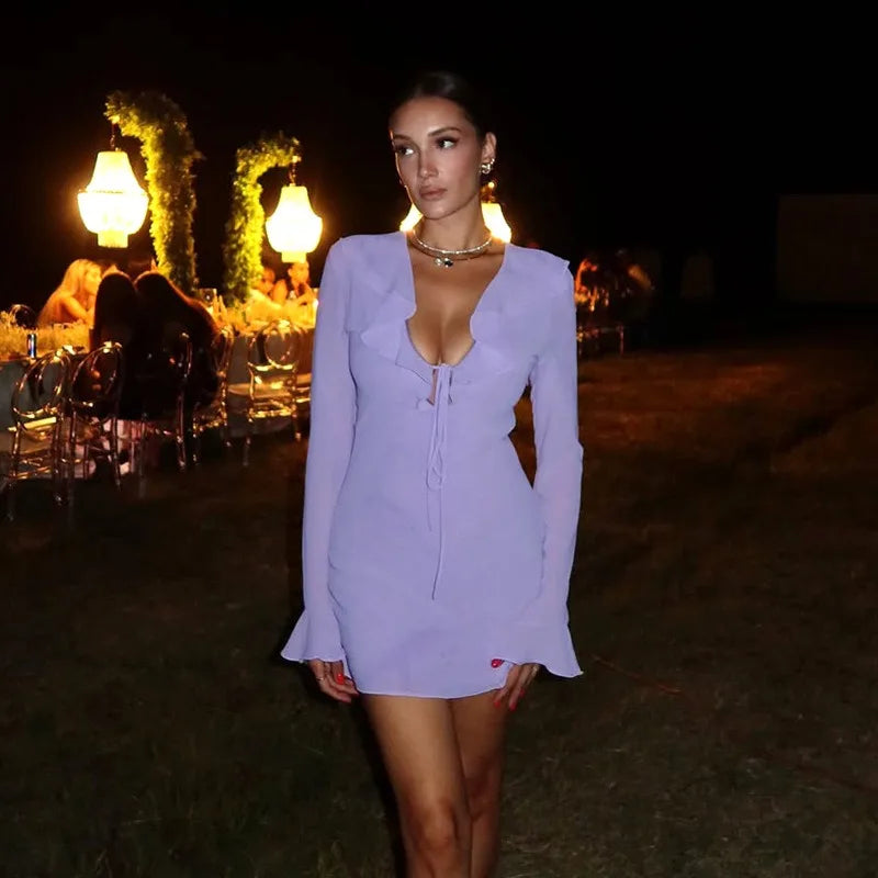Woman wearing purple ruffled v-neck mini dress at night event