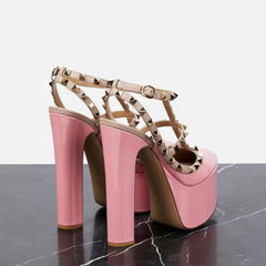 Pink high-heeled shoes with studded details on a dark surface