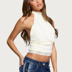 Woman wearing a white sleeveless top with lace trim and blue jeans on a light gray background