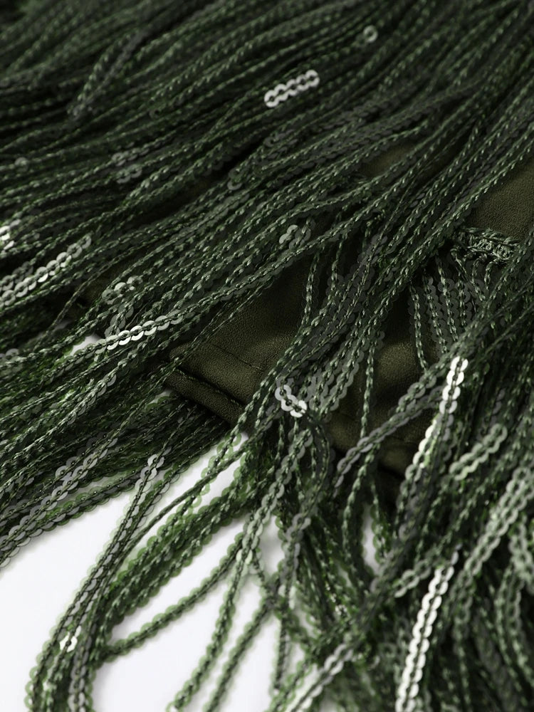 Close-up of dark green tassels on a white background