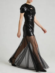 Black sequin mini dress with sheer tulle maxi overlay, model walking.