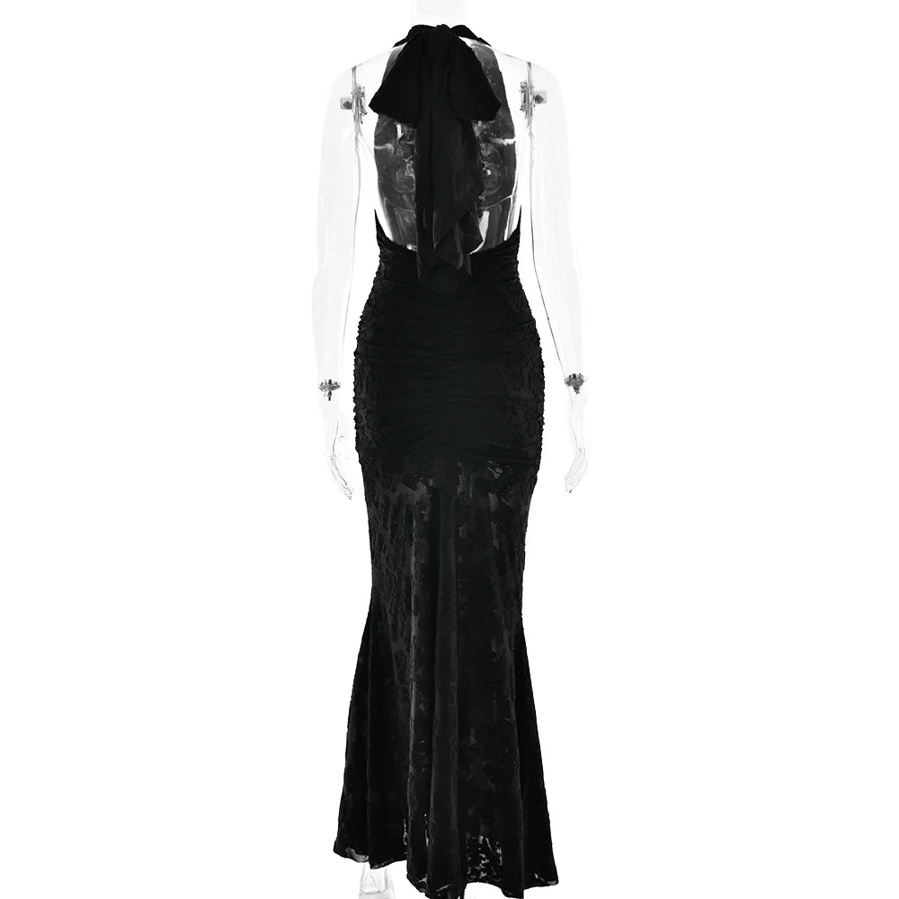 Black evening gown with sheer overlay on a white background