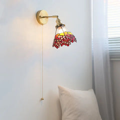Wall-mounted lamp with stained glass shade on a white wall