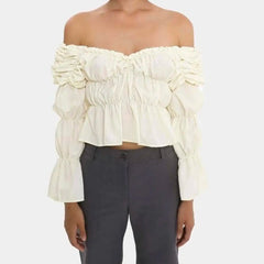 White off-shoulder ruffled top worn by a person on a white background