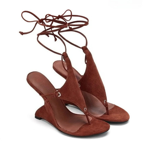 Brown suede sandals with tie-up straps on a white background