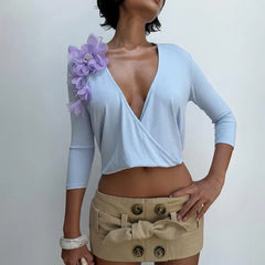 Light blue wrap top with floral shoulder embellishment from a different angle.