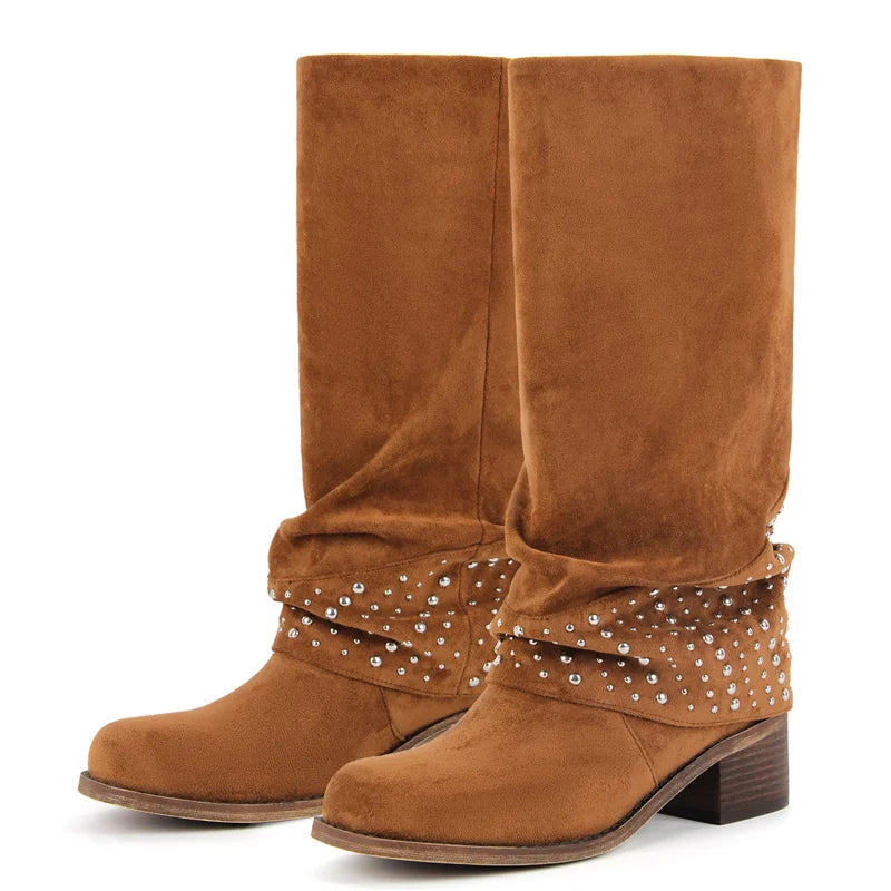 Pair of brown faux suede knee-high boots with a fold-over cuff adorned with silver studs, set against a white background.