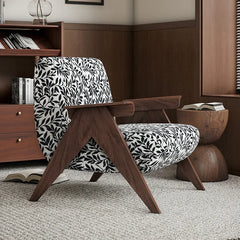 Wooden chair with black and white patterned cushion in a room with wooden furniture and books.