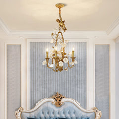 Decorative chandelier hanging above a blue upholstered chair in a room with light gray walls.