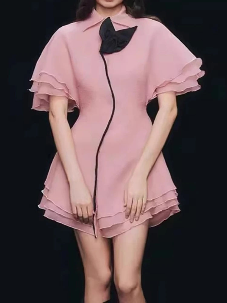 Pink dress with black accents on a black background