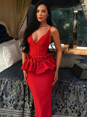 Woman in a red dress standing in an elegant room with decorative elements.