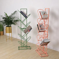 Golden Atelier tree-shaped bookshelf made of black metal grid with multiple shelves for displaying and storing books in a living room setting. Green  & Pink