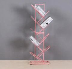 Golden Atelier tree-shaped bookshelf made of black metal grid with multiple shelves for displaying and storing books in a living room setting. Pink