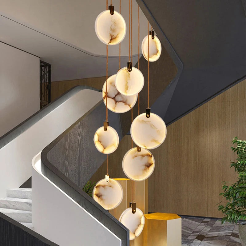 Alabaster disc staircase chandelier in a sculptural double height entry