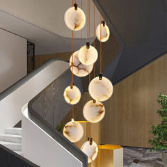 Alabaster disc staircase chandelier in a sculptural double height entry