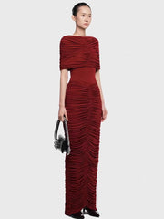 Straight-on silhouette shot emphasizing the sculpted drape and gathered detailing from bodice to skirt, styled for a formal evening.