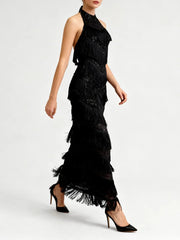 Lower-half detail of the black ankle-length skirt showing layered tassel trim finishing the hem with a soft, swaying effect.