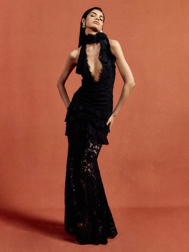 Appliqué black gala dress for women shown against statement red background